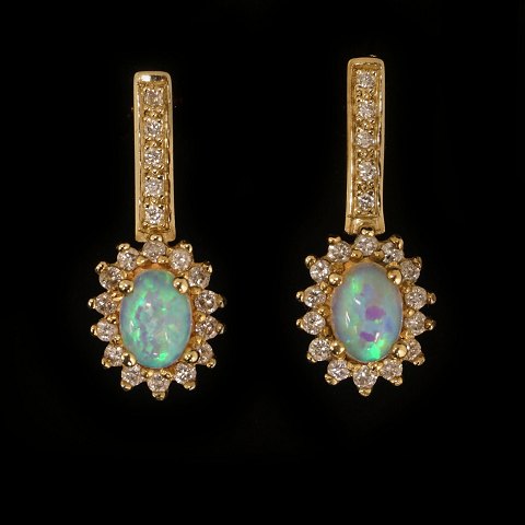 Ein Paar Ohrringe aus 14kt Gold je mit einem 
ovalen Opal und 19 Diamanten von etwa 0,015ct. H: 
24mm. B: 10mm