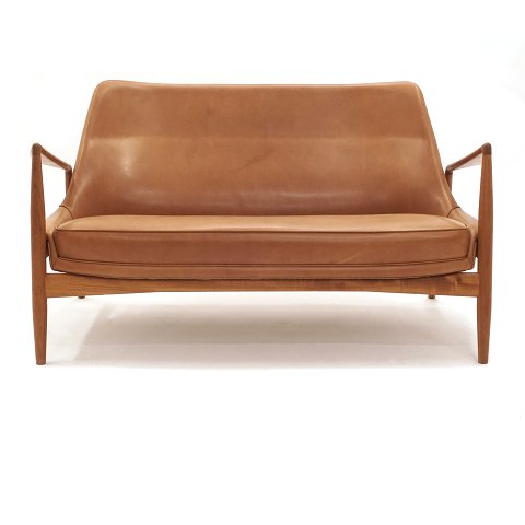 Ib Kofod-Larsen zwei Personen Sofa aus Teak 
bezogen mit patiniertem Leder. Design aus dem 
Jahre 1957. L: 138cm