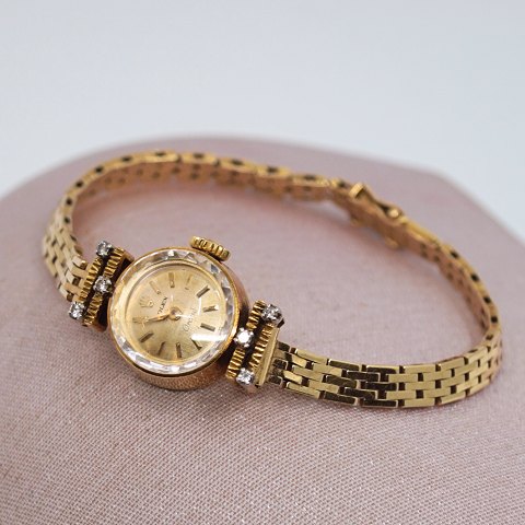 Rolex; Orchid watch in 18k gold with diamonds, with chain in 14k gold