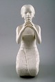 Harald Salomon for Rörstrand, white glazed figure of Balinese holding flower in 
her hand.