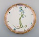 Dinner plate in Flora Danica style. Hand-painted flowers and gold decoration. 
Mid-20th century.
