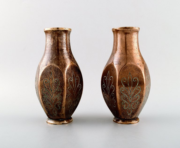 A pair of art deco Tinos Bronze vases in massive patinated bronze molded with 
foliage.