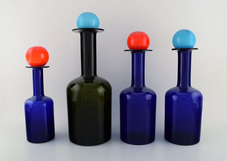 Otto Brauer for Holmegaard. A collection of four large vases / bottles in dark 
blue and green art glass with lids in the shape of a ball. 1960