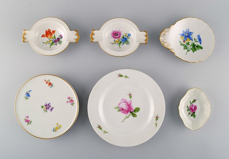 A collection of hand-painted Meissen porcelain. Early 20th century. Consisting 
of table trivet, plate and three small bowls / dishes.