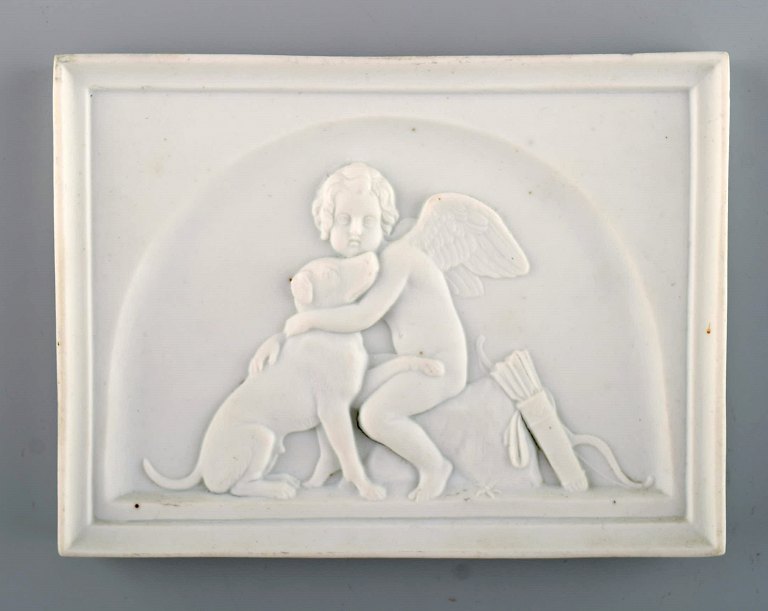 Bing and Grondahl after Thorvaldsen. Antique biscuit wall plaque. Cupid and a 
dog. Late 19th century.
