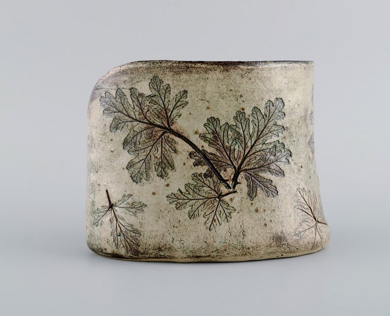 Swedish studio ceramicist. Unique vase in glazed ceramics decorated with 
foliage. Dated 1985.
