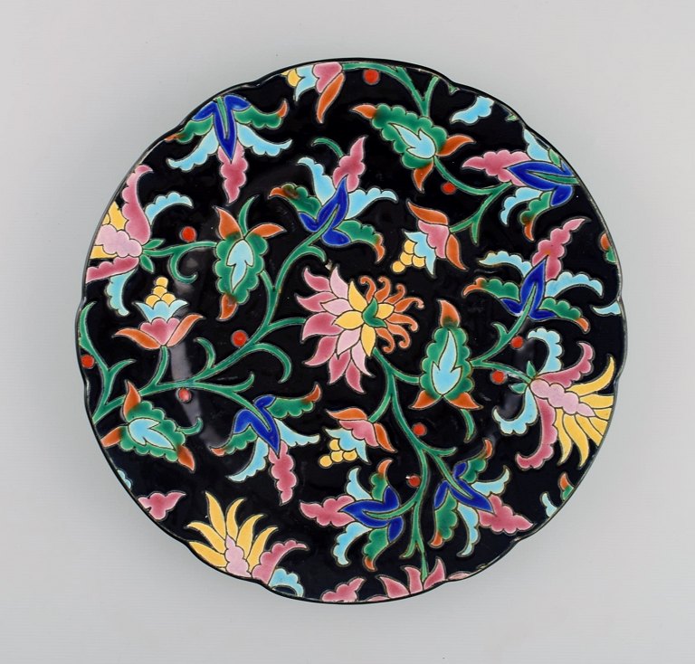 Longwy, France. Art deco plate in glazed stoneware with hand-painted flowers and 
foliage on a black background. 1920s / 30s.
