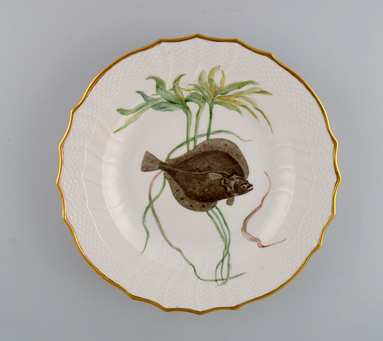 Royal Copenhagen porcelain dinner plate with hand-painted fish motif and golden 
border. Flora / Fauna Danica style. Dated 1968.
