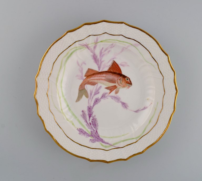 Royal Copenhagen porcelain dinner plate with hand-painted fish motif and golden 
border. Flora / Fauna Danica style. Dated 1955.
